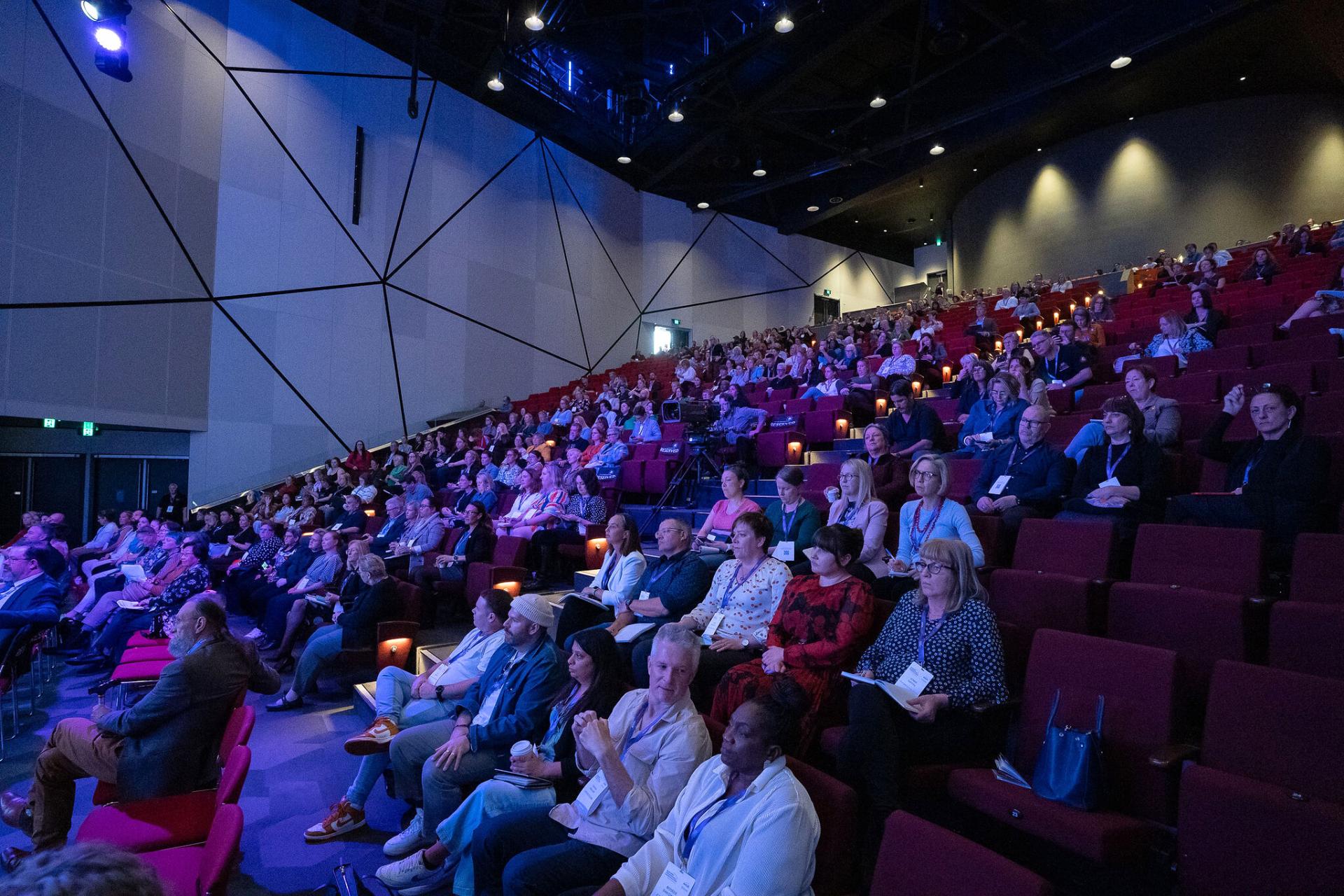 Wide shot of crowd sitting in auditorium at Australian Homelessness Conference 2024