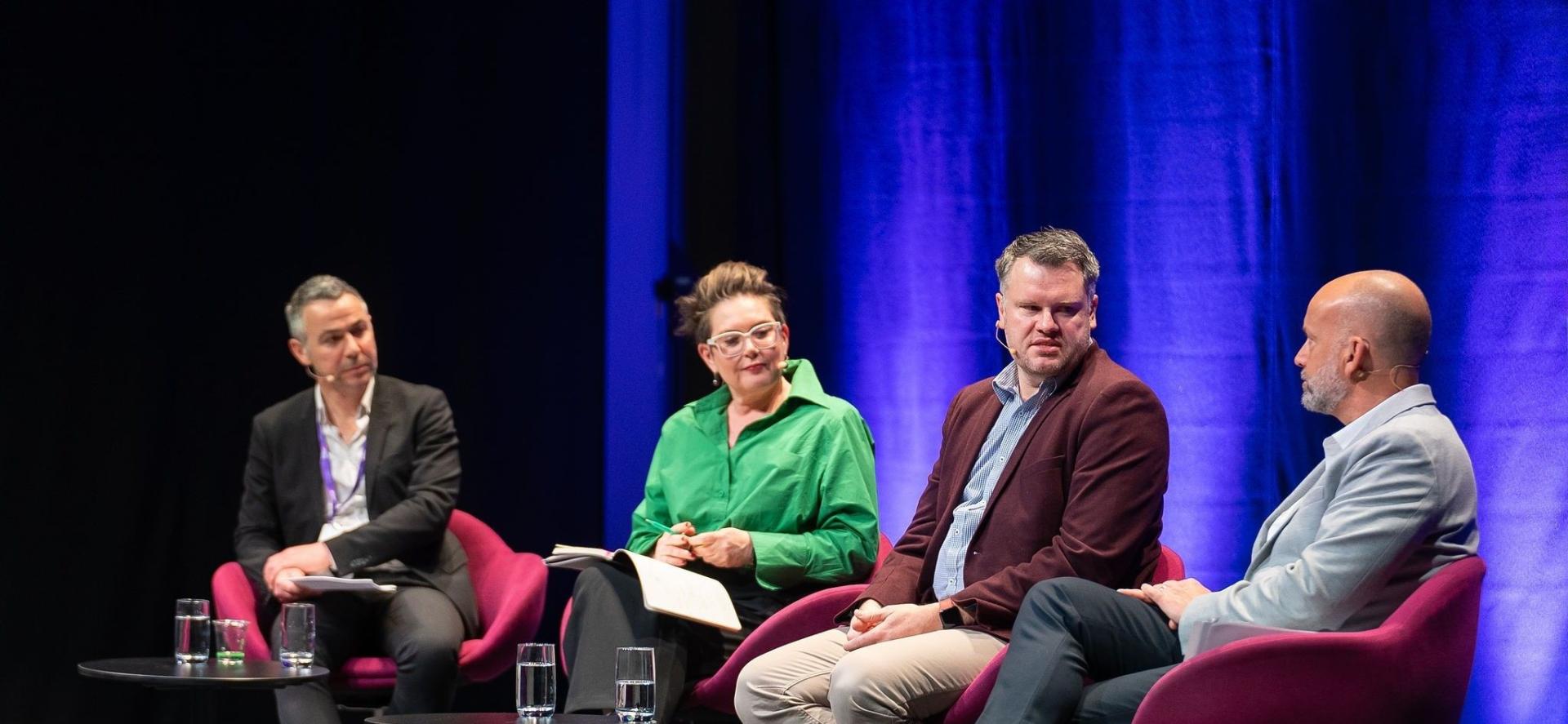 Four speakers in sitting in a row holding a discussion at Australian Homelessness Conference 2024